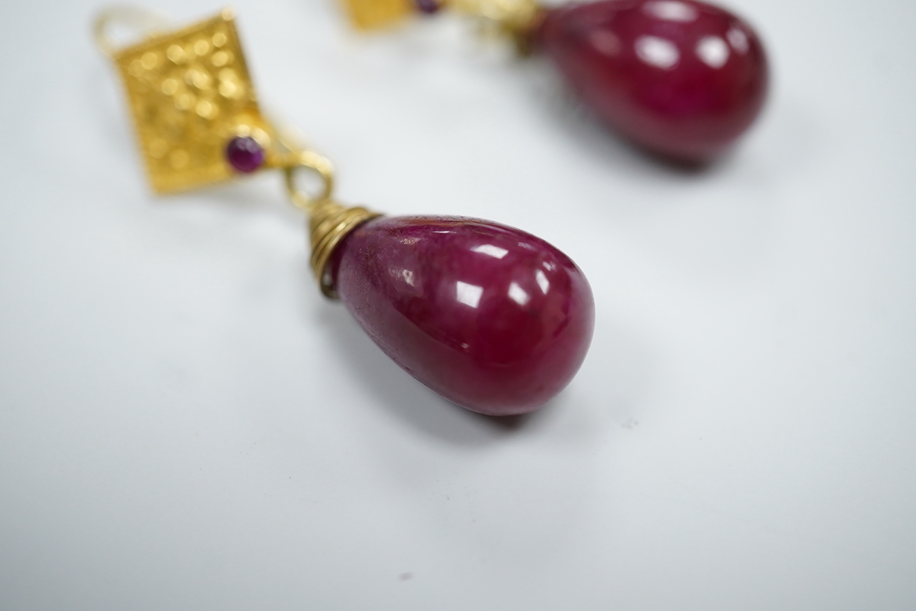 A pair of yellow metal and two stone ruby set teardrop shaped earrings, overall 37mm, gross weight 7.2 grams.